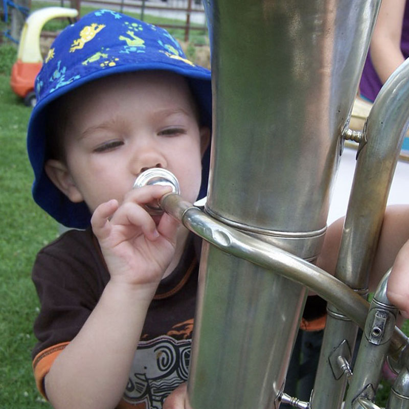 Child exploring Tuba at Island Arts