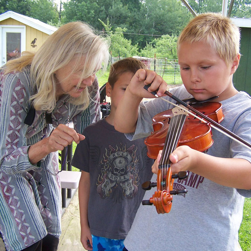 Child exploring a violin Photo by Island Arts